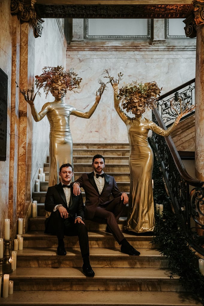 unique wedding vendors Grooms posing with unique Live Art Installation of Gold Trees